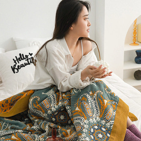 Woman relaxing under soft cotton quilt with floral bohemian design