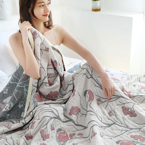 Girl wrapped in cotton quilt with delicate bird and berry design