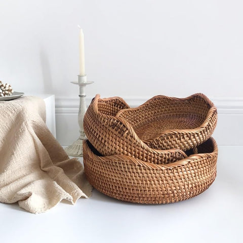 Stack of three empty rattan baskets for storage on white background