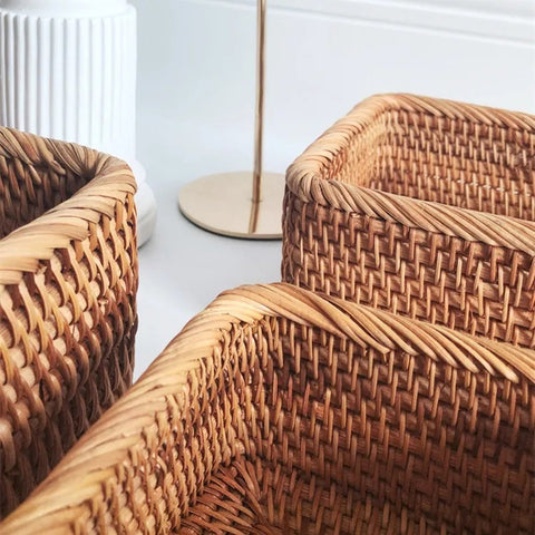 Close-up of woven wicker chairs with a white wall in the background