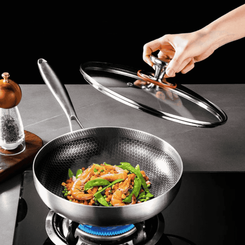 Stainless frying pan with lid on gas stove cooking vegetables