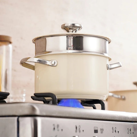 Steamer pot from cream enamel cookware set in use with flame