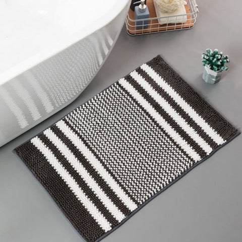 Black and white striped chenille mat beside a bath.