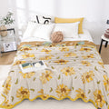 Cozy queen bed with sunflower print cotton gauze quilt and soft lighting