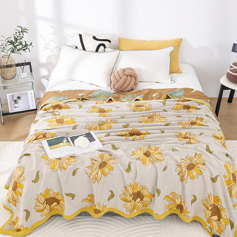 Cozy queen bed with sunflower print cotton gauze quilt and soft lighting