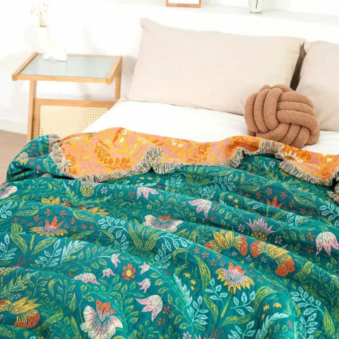 Reversible cotton blanket on bed with green floral botanical print