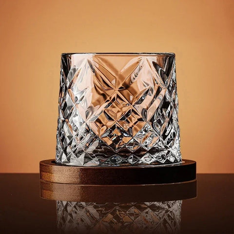 Tall cut-glass whiskey tumbler on wooden coaster