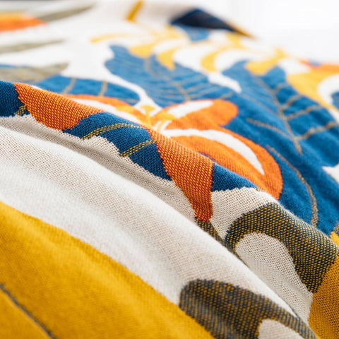 Close-up of terracotta fields cotton blanket fabric highlighting vibrant pattern and soft woven texture