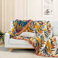 Terracotta Fields Cotton Blanket draped on white sofa showing bold geometric and floral pattern with warm terracotta trim