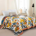 Terracotta Fields Cotton Blanket with warm rustic patchwork design draped over bed in cozy bedroom setting
