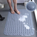 Person standing on a textured non-slip shower mat with soap foam