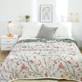 Bed styled with Tree Bird reversible cotton quilt in bright morning light