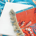 Close-up fabric detail of tropical floral reversible cotton throw blanket with fringe edges