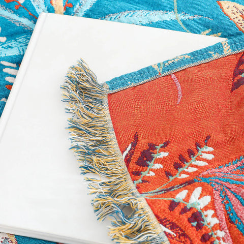 Close-up fabric detail of tropical floral reversible cotton throw blanket with fringe edges