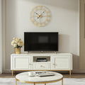 Gold decorative wall clock above TV stand in modern neutral-toned living room

