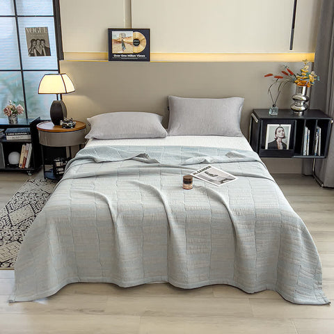 Light blue cotton quilt neatly laid out on minimalist bed