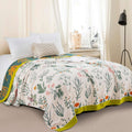Verdant Bloom Cotton Throw Blanket spread over bed in bright, airy bedroom with pillows and natural decor