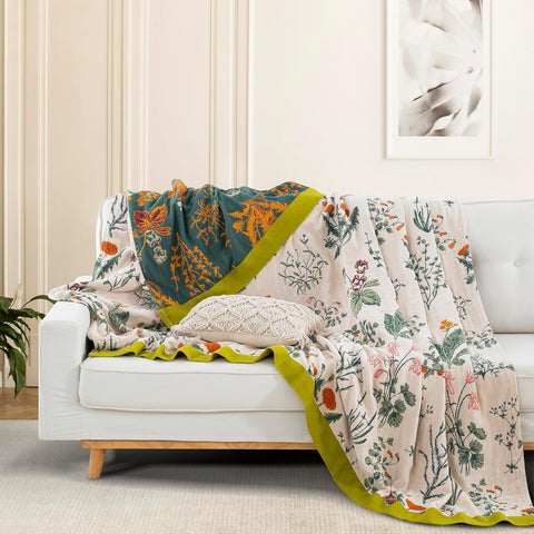Verdant Bloom cotton throw blanket draped over white sofa with macrame pillow and plant decor