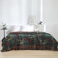 Vintage boho cotton throw blanket with floral pattern draped on a bed in a bright, minimalist bedroom setting with white pillows and soft natural light