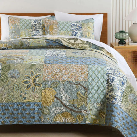 Vintage floral patchwork quilt on light wood bed with matching shams