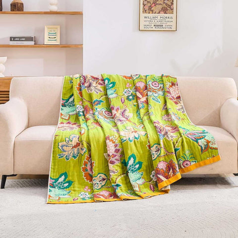 Vintage Garden Cotton Throw Blanket blanket with warm floral patterns gracefully spread over a beige sofa in a sunlit living room