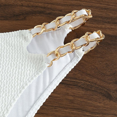 Close-up of double gold chain straps on white high-waisted bikini bottom