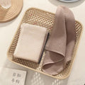 Beige and pink towels folded in a woven storage basket