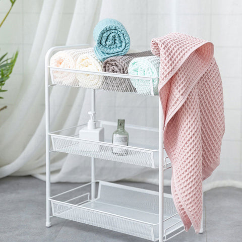 Pastel waffle cotton towels hanging on white display rack