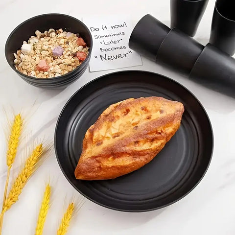 Baked good on a black plate with a bowl of granola and coffee cups in the background.