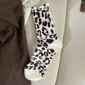 White leopard sock flat lay