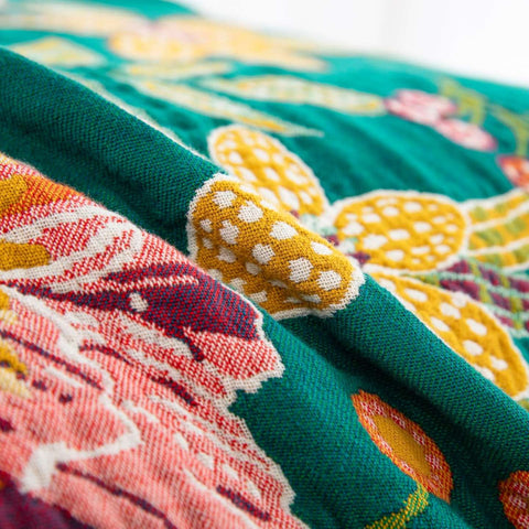Detailed close-up of colorful floral jacquard weaving on Wildflower Grove Cotton Throw Blanket