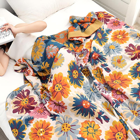 Woman laying in bed comfortably covered with Daisy Flower Cotton Blanket in bedroom