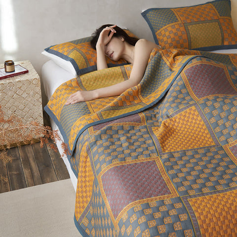 Woman relaxing in bed with retro cotton quilt in earthy tones