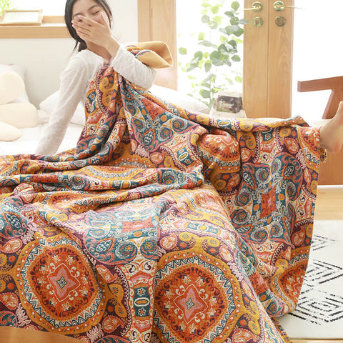 Woman stretching large bohemian quilt next to bed
