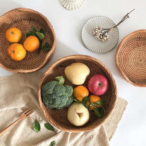 Small and medium woven fruit baskets with assorted fruits on neutral table setting